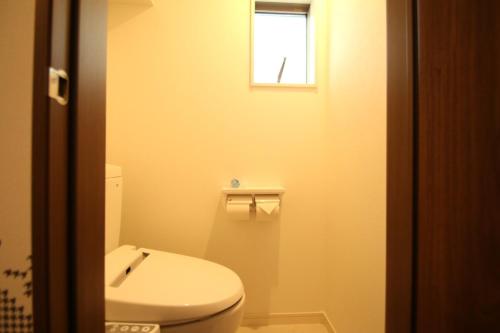 a bathroom with a white toilet and a window at Casa上熊本2 in Kumamoto
