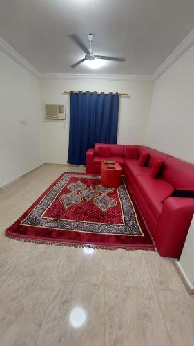 a living room with a red couch and a red rug at Salalah Peace House in Salalah