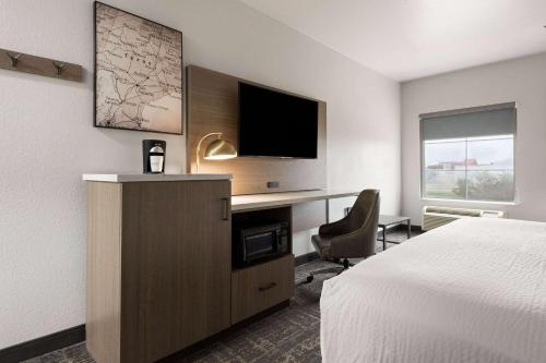 une chambre d'hôtel avec un lit et un bureau avec une télévision dans l'établissement La Quinta by Wyndham Ft. Worth - Forest Hill, TX, à Forest Hill