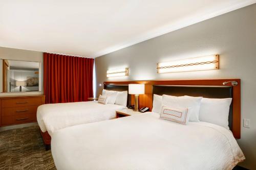 a hotel room with two beds and a mirror at SpringHill Suites Denver at Anschutz Medical Campus in Aurora