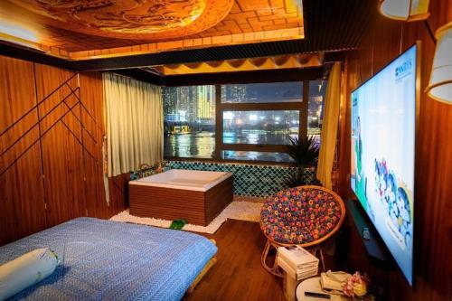 a bedroom with a tv and a tub and a window at Hotel massage RiverSide in Ấp Buo18i Cán
