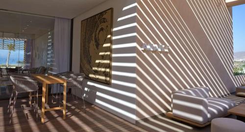 a dining room with chairs and a table and a wall at Hilton Taghazout Bay Beach Resort & Spa in Taghazout