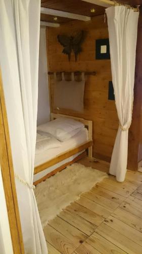 - une petite chambre avec un lit et un rideau dans l'établissement Chalet Espace Lumière - Spa, sauna et salle de fitness, à Méolans