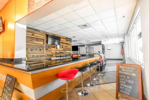 a bar in a restaurant with red stools at Ramada by Wyndham Flamingo Water Park in Kissimmee