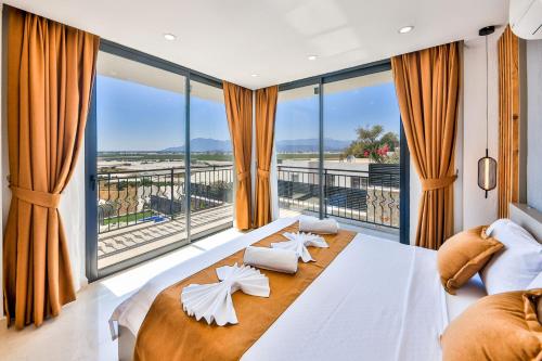 a bedroom with a large bed and a large window at Villa Maranga in Kalkan