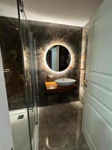 un bagno con lavandino e specchio di Skyline Soak, Views & Jacuzzi a San Giuliano