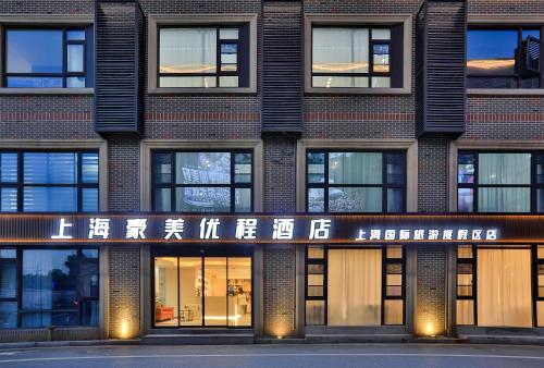 a building with a sign on the front of it at Shanghai Meihao Premium Journey Hotel - Shanghai International Tourism Resort Store in Shanghai