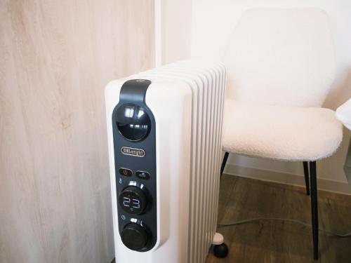 a remote control sitting next to a white chair at グランディオーソ中野富士見町 in Tokyo