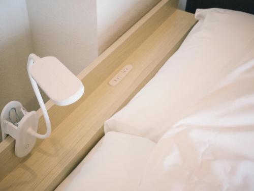 a room with two beds with a white bed sidx sidx sidx at グランディオーソ中野富士見町 in Tokyo