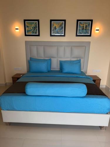 a bedroom with a large bed with blue pillows at Mzion Hotel Weligama in Weligama