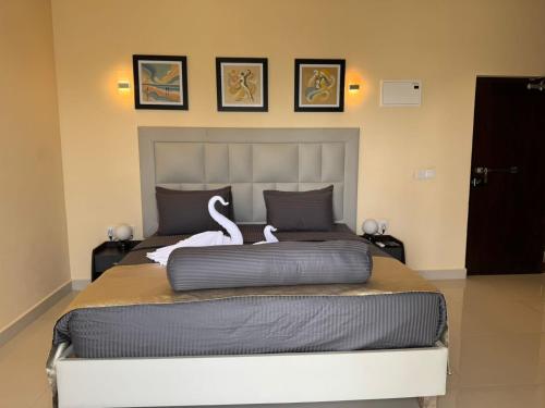 a bedroom with a large bed with two swans on it at Mzion Hotel Weligama in Weligama
