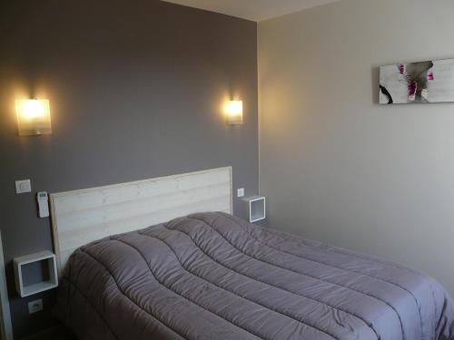 - un lit dans une chambre avec deux lumières sur le mur dans l'établissement Maison Lotoise - Rocamadour - Padirac and Sarlat, à Saint-Sozy