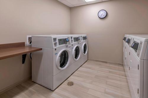 a laundry room with two washing machines and a clock at TownePlace Suites by Marriott Leavenworth in Leavenworth
