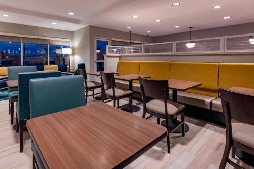 a dining room with tables and chairs and windows at TownePlace Suites by Marriott Leavenworth in Leavenworth