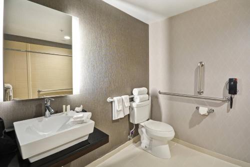 a bathroom with a toilet and a sink and a mirror at SpringHill Suites by Marriott Indianapolis Airport/Plainfield in Plainfield