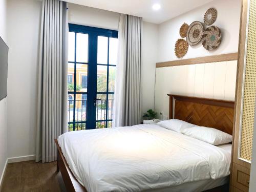 a bedroom with a bed and a large window at Villa 4 bedrooms, 5 bathrooms, sea view at NovaWorld Phan Thiet 53 in Bình Tú