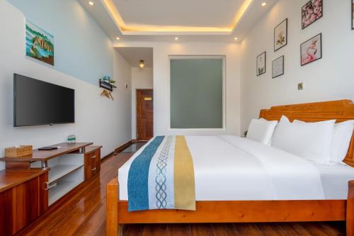 a bedroom with a large bed and a tv at Dali Ancient Town-Jinbi Yayuan Inn in Dali