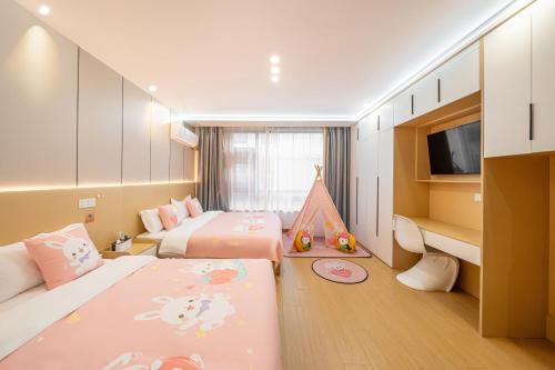 a hotel room with two beds and a tv at Shanghai Meihao Premium Journey Hotel - Shanghai International Tourism Resort Store in Shanghai