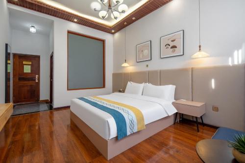 a bedroom with a large white bed and a window at Dali Ancient Town-Jinbi Yayuan Inn in Dali
