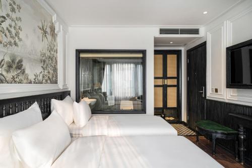 a bedroom with a white bed and a television at Luxe Paradise Premium Hotel and Spa in Hanoi