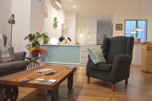 a living room with a coffee table and a chair at Hotel Smile & Co Hostal Boutique in Alicante