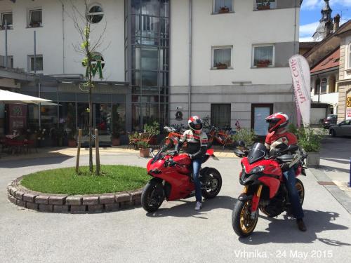two people on motorcycles parked in front of a building at Hotel MANTOVA Vrhnika in Vrhnika