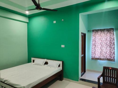 a green bedroom with a bed and a window at Hotel Shree Ram in Kishangarh