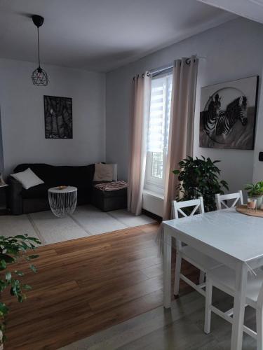 un salon avec une table blanche et un canapé dans l'établissement Appartement avec stationnement gratuit, à Troyes