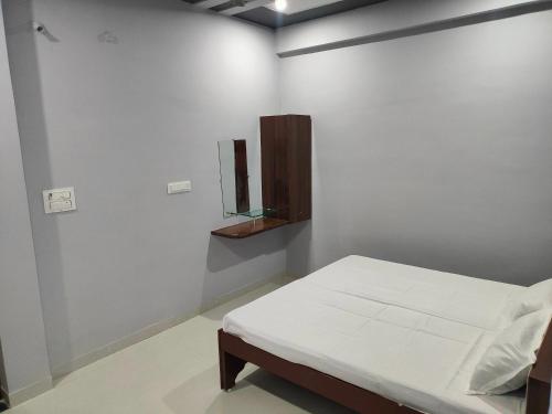 a white room with a bed and a mirror at Hotel Shree Ram in Kishangarh