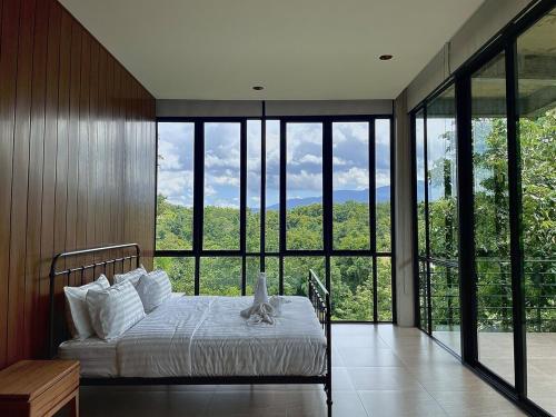 Ban Thung Pa HaeoにあるStarry Hill House Chiangmai - บ้านสวนชมดาวのベッドルーム1室(ベッド1台、大きなガラス窓付)