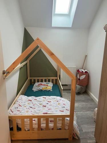 Cette chambre comprend un petit lit à baldaquin. dans l'établissement Maison à Luc sur Mer, à Luc-sur-Mer