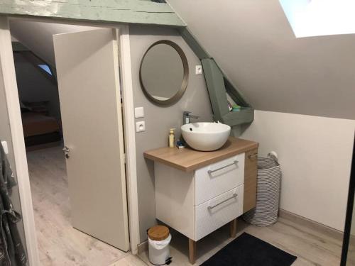 une salle de bain avec un lavabo et un miroir dans l'établissement Maison à Luc sur Mer, à Luc-sur-Mer