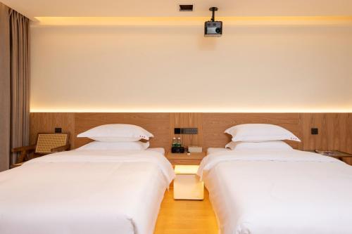 two beds in a room with white sheets at Yangshuo Hidden Dragon Villa in Yangshuo