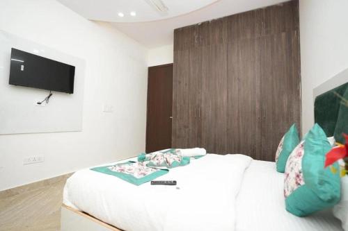 a bedroom with a bed and a tv on a wall at Hotel Diamond Stay 10 Mints Walking From Nizamuddin Railway Station in New Delhi