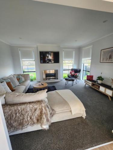 sala de estar amplia con sofá y chimenea en Relaxing Home Close 2 Beach With Spa - Pool Nov!, en Papamoa