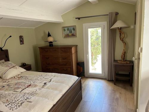 une chambre avec un lit, une commode et une fenêtre dans l'établissement Petite Maison de Charme, à Auriol