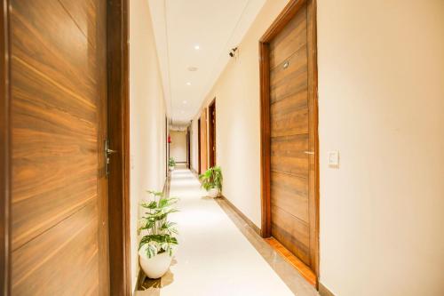 a hallway with potted plants and a wooden door at Townhouse Grand Fortune in Amritsar