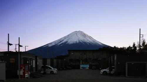 a snow covered mountain in the background of a parking lot at Mt Fuji Glamping TOURIST VILLA Kawaguchiko in Fujikawaguchiko
