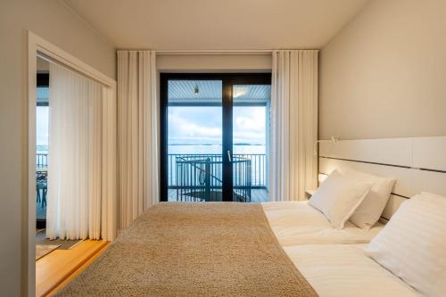 a bedroom with a bed with a view of the ocean at Ocean Pearl Suite in Kuningatarranta Hanko in Hanko