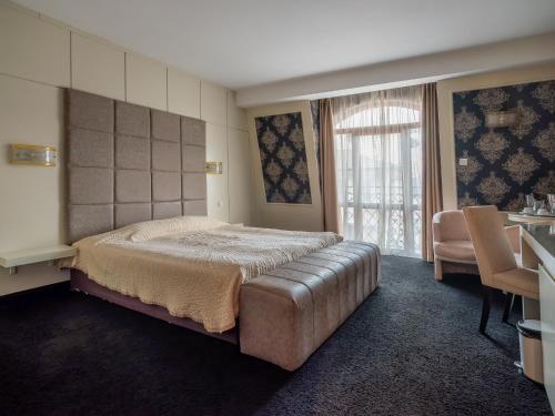 una camera da letto con un letto grande e un tavolo di Hotel Concorde a Veliko Tŭrnovo