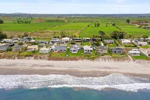 an aerial view of a beach with houses at Family Holiday at the Beach! in Pukehina