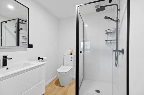 a bathroom with a shower and a toilet and a sink at Family Holiday at the Beach! in Pukehina