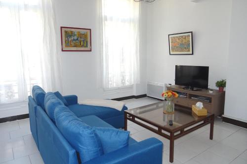 un salon avec un canapé bleu et une table basse dans l'établissement Joli T2 refait à neuf, lumineux et accessible, à Marseille