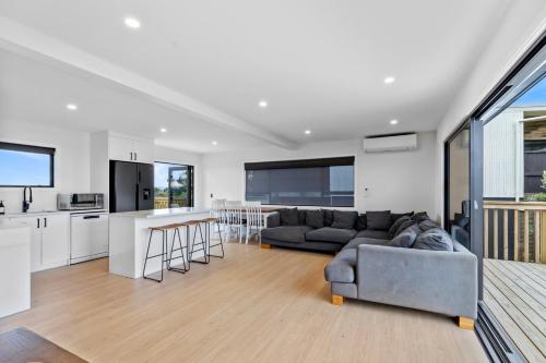 a living room and kitchen with a couch and a table at Family Holiday at the Beach! in Pukehina