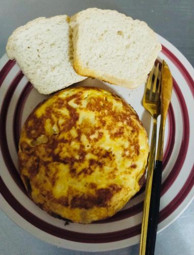 un huevo en un plato con pan y un tenedor en La Lola, en San Vicente