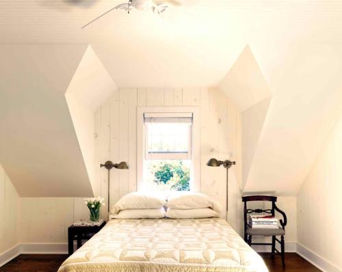 ein Schlafzimmer mit einem großen Bett mit Fenster in der Unterkunft Shelter Island Hidden Estate in East Marion