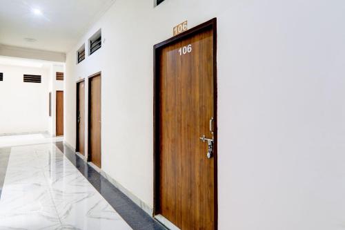 a hallway with a wooden door in a building at Hotel O Serene Inn Hotel And Restaurant in Lucknow