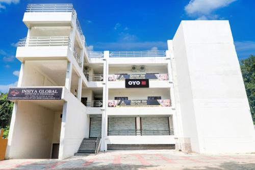 a white building with a sign in front of it at Hotel O Serene Inn Hotel And Restaurant in Lucknow