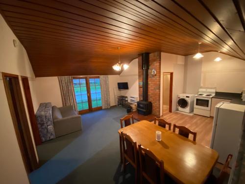 a living room with a dining table and a kitchen at Oultan Homestead Farm Stay in Ikamatua