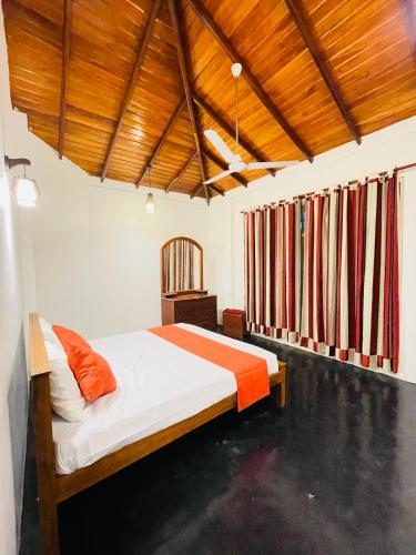 a bedroom with a bed in a room with wooden ceilings at Blue Moon Villa in Weligama